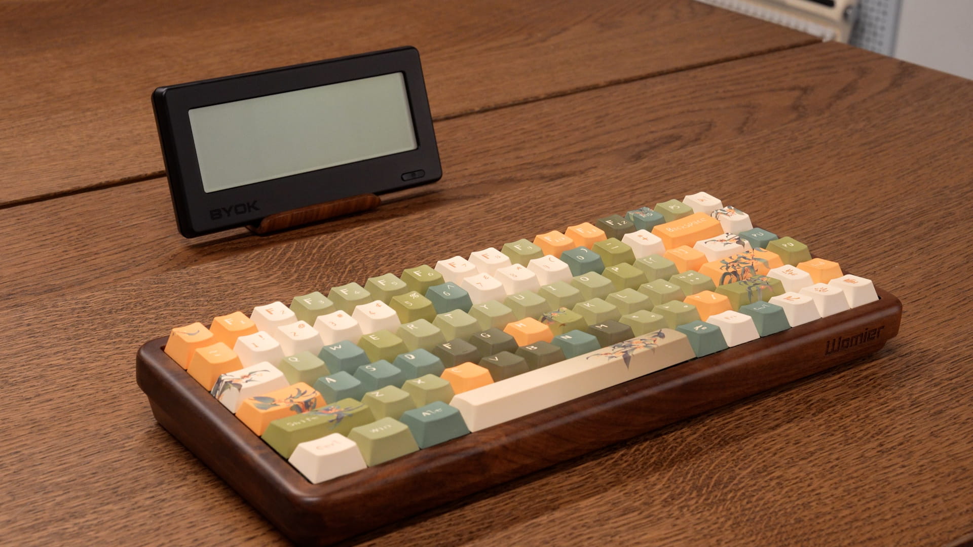 BYOK resting in a wooden stand behind a wooden mechanical keyboard