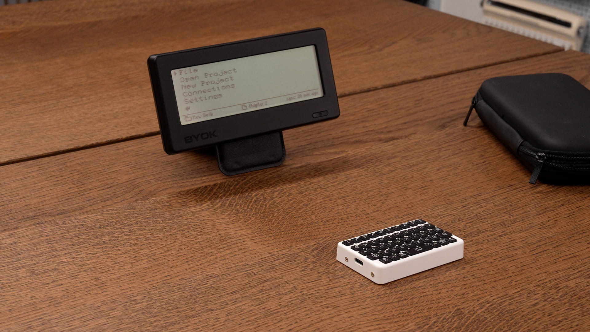 BYOK standing on a folded wallet stand beside a tiny pocket keyboard