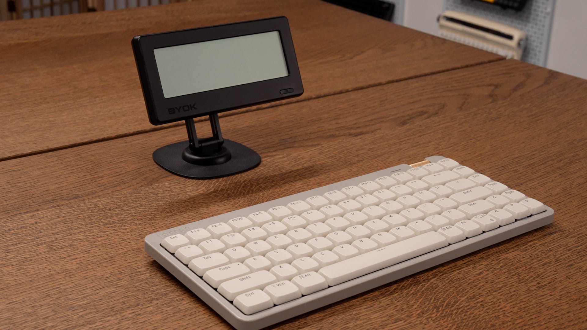 BYOK tilted on the accessory bundle desk stand behind a low-profile keyboard