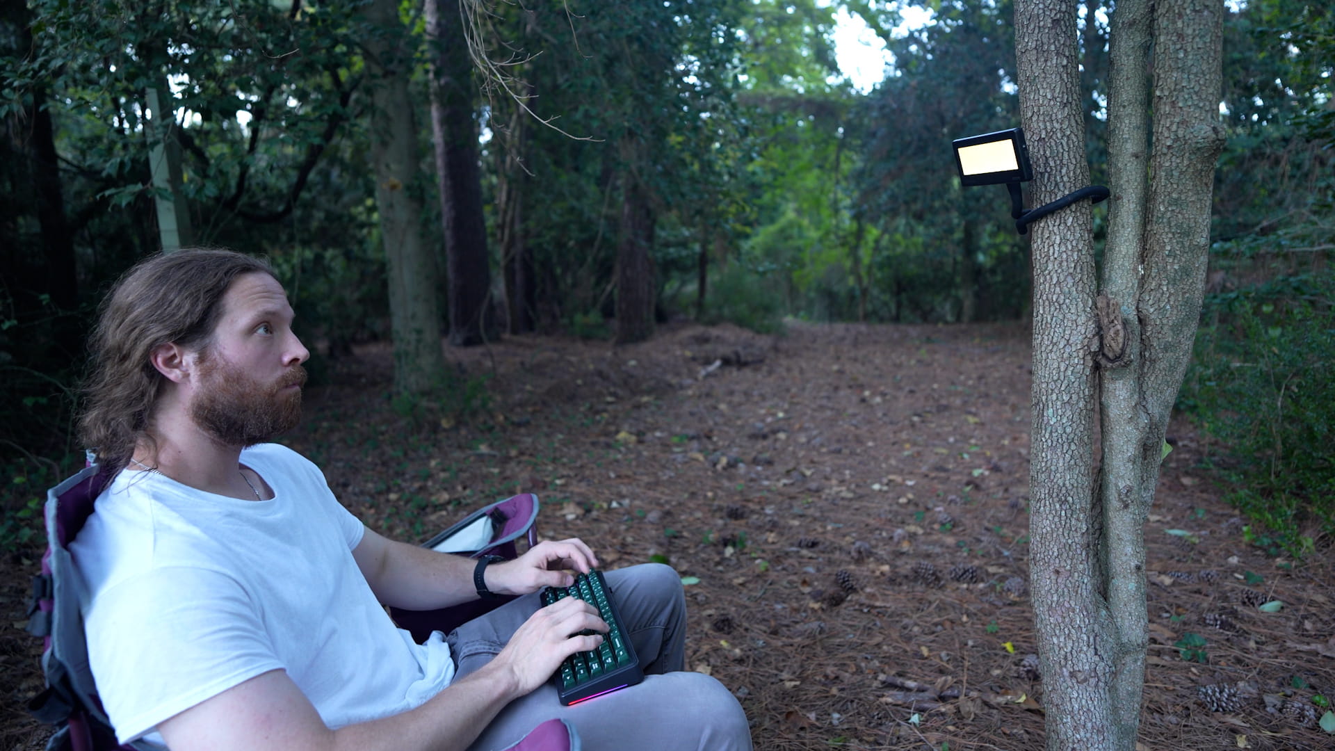 BYOK held by a flexible arm wrapped around an object beside a mechanical keyboard