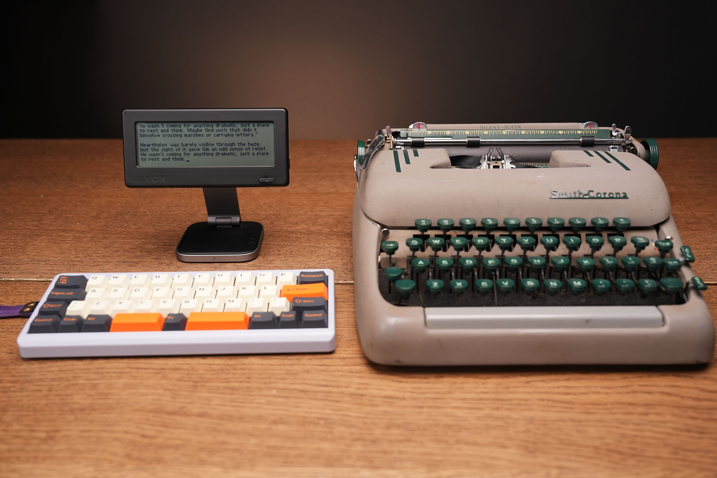 BYOK modern digital typewriter-style writing device beside a traditional typewriter