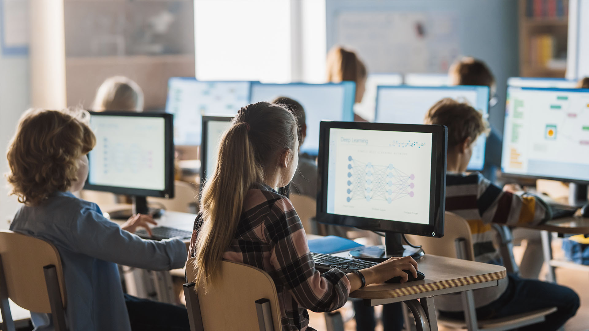 Students in a classroom using laptops and tablets