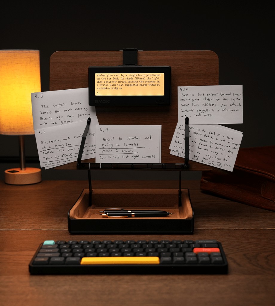 BYOK writing device on a stand with index cards and a mechanical keyboard in a focused writing setup