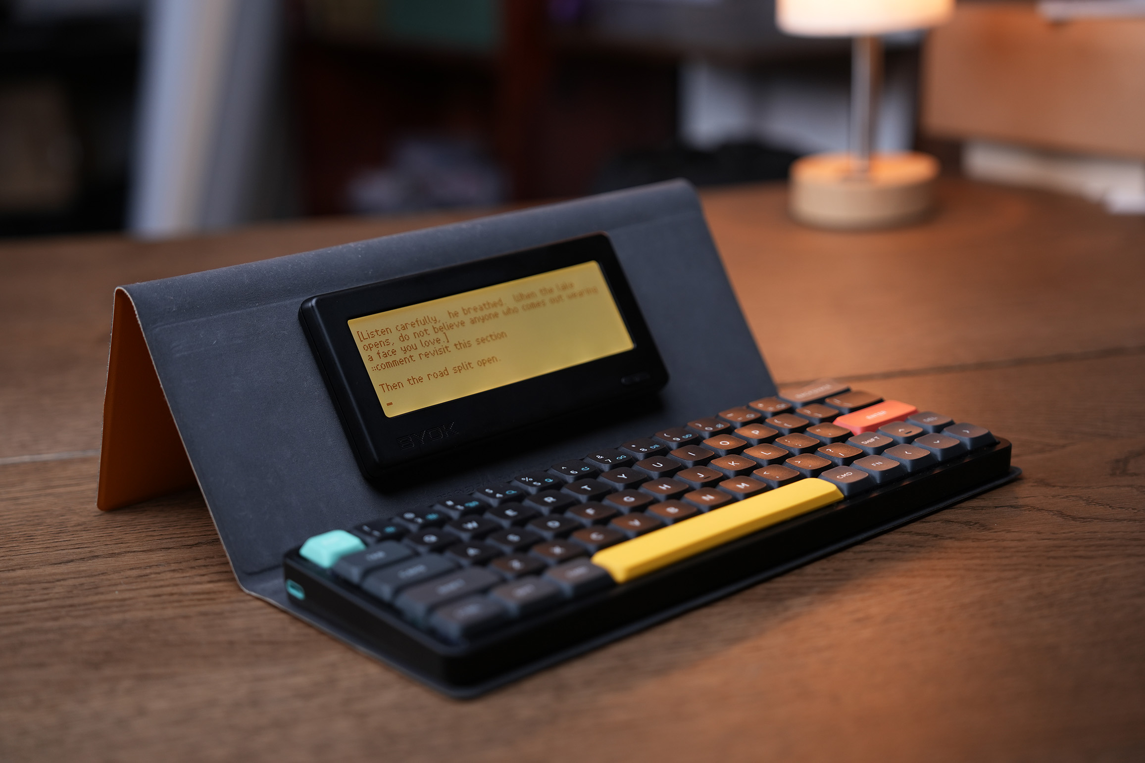 BYOK in its folio case with keyboard, mid-draft under warm lamplight
